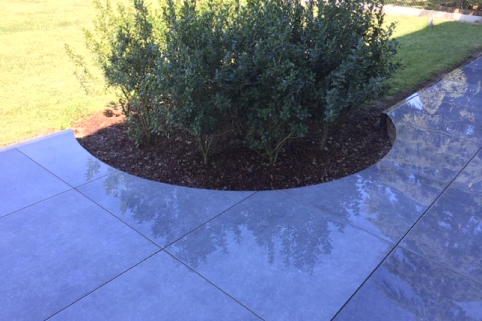 Aanleg terras in keramische tegel 90/90 met integratie plantenborder.