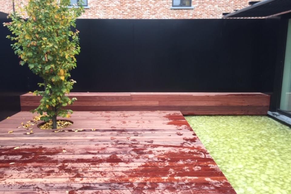 Aanlig Patio met siervijver en hardhouten terras in padouk met zitbank en plantenborder.