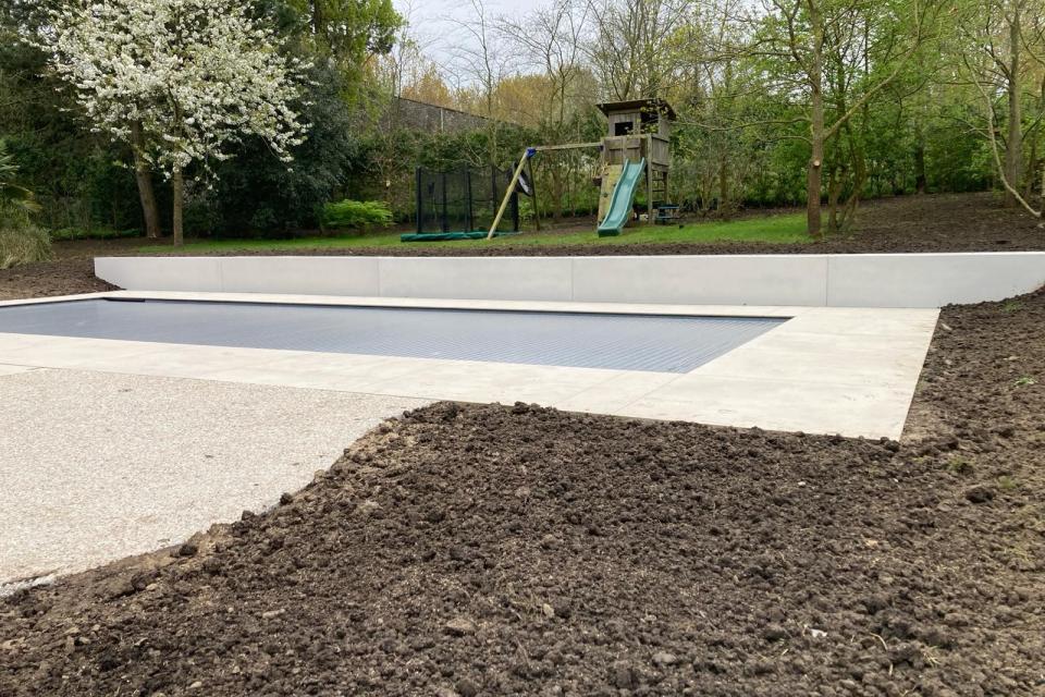 Plaatsen van betonnenafboording tegen zwembad