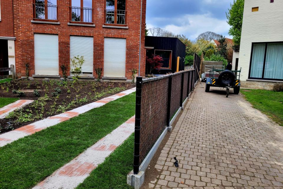 Schutting met draad, heidematten, klimplanten en betonplaten geplaatst ter privacy en watermanagement