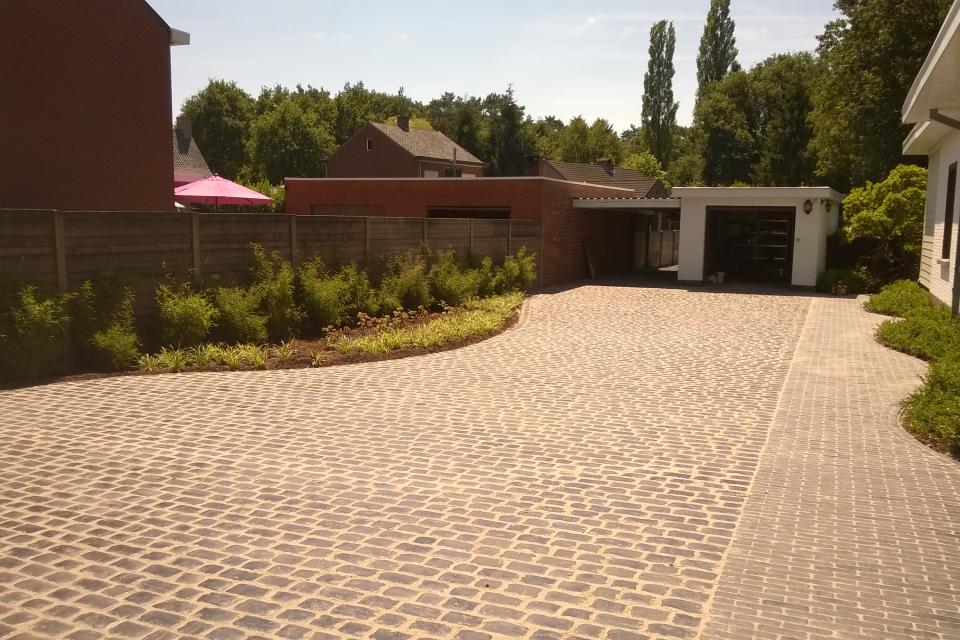 Totaal project tuinrenovatie uit ontwerp: grondwerken, gazon, oprit, waterafvoeren, terras, aanplantingen en verlichting
