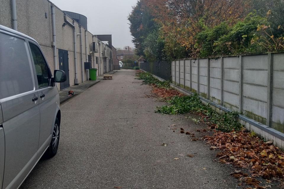 Onderhouden gemeenschappelijke weg achter winkelruimtes.