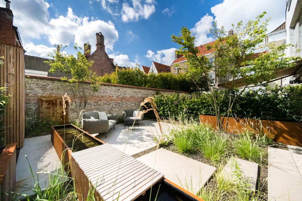 Een kleine stadstuin te Brugge. Hier werd gewerkt met een vijver in cortenstaal, Cehmer en een variatie aan beplanting.