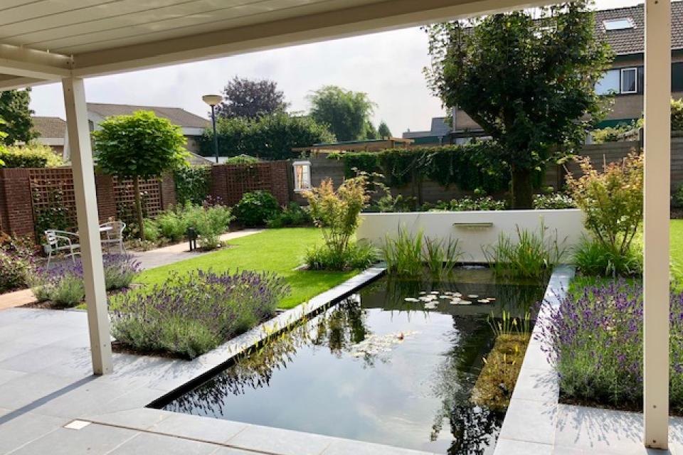 Strakke tuin met vijver en lijnwaterval in aluminium wand
