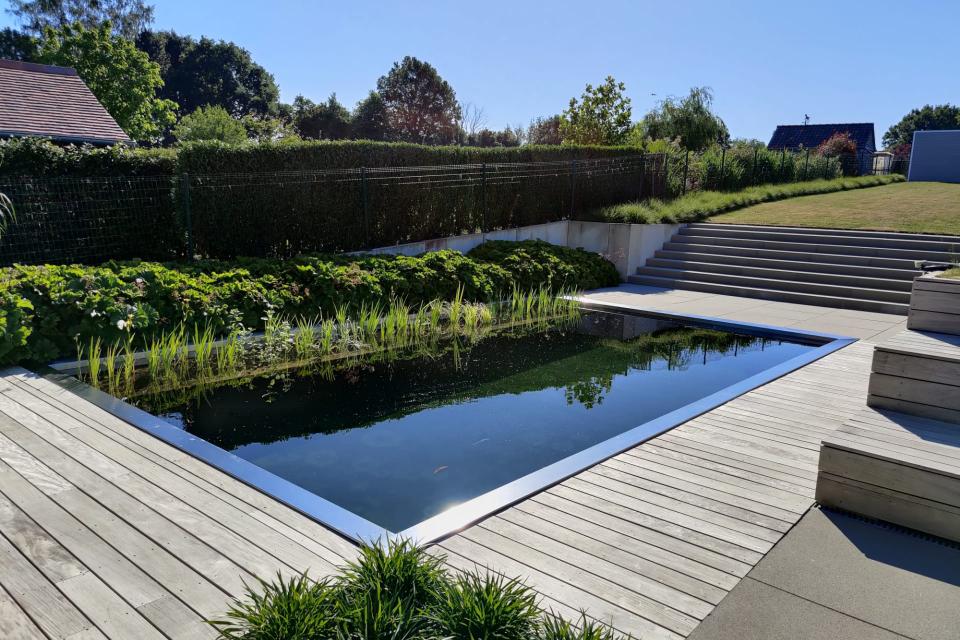 Totaalproject aanleg van zwemvijver met inox boord, terras in hout en megategels en aanplanten van tuin te Liedekerke